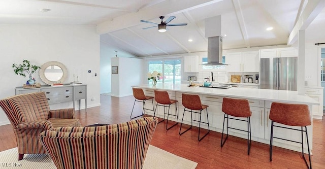 932 Bell Rd, Chagrin Falls, OH 44022 - kitchen featuring freestanding refrigerator, island range hood, white cabinets, a ceiling fan, and decorative backsplash