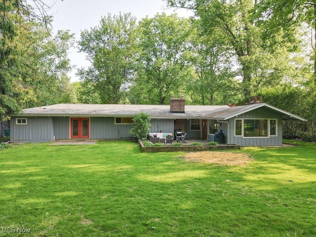 932 Bell Rd, Chagrin Falls, OH 44022 - back of house featuring french doors, a lawn, a chimney, board and batten siding, and an outdoor hangout area