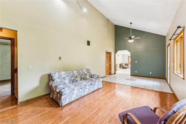 43628 Crestview Rd, Columbiana, OH 44408 - living room featuring light wood-style flooring, a ceiling fan, high vaulted ceiling, and baseboards