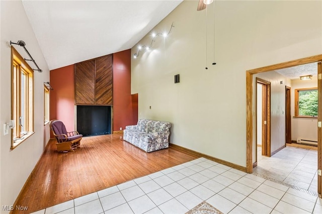 43628 Crestview Rd, Columbiana, OH 44408 - living area featuring a baseboard heating unit, light tile patterned floors, high vaulted ceiling, and baseboards