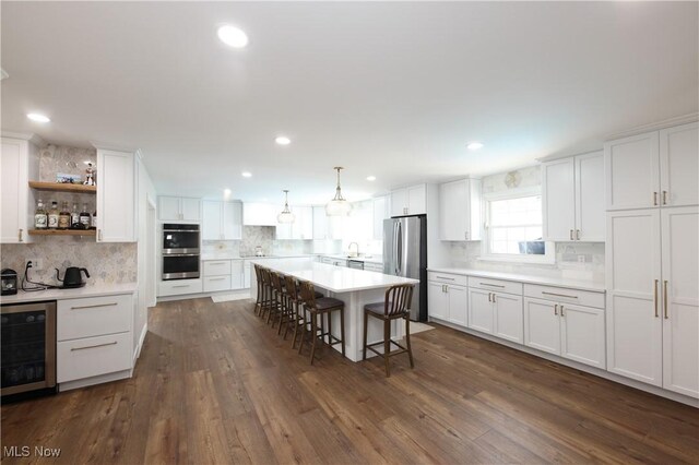327 Country Club Blvd, Weirton, WV 26062 - kitchen with beverage cooler, stainless steel appliances, backsplash, a kitchen breakfast bar, and white cabinets