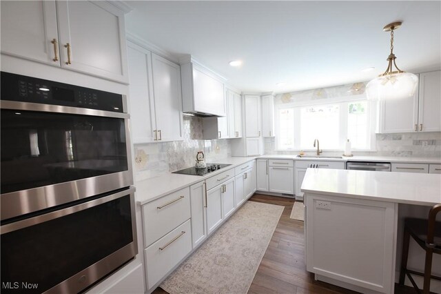327 Country Club Blvd, Weirton, WV 26062 - kitchen featuring stainless steel appliances, a sink, dark wood-type flooring, light countertops, and a breakfast bar