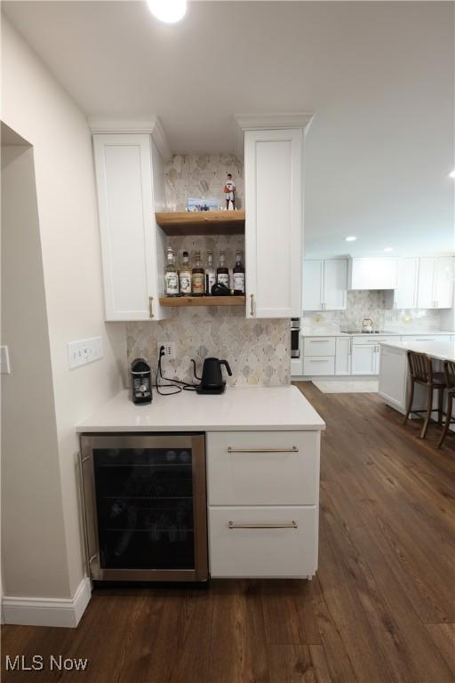 327 Country Club Blvd, Weirton, WV 26062 - indoor dry bar featuring wine cooler, decorative backsplash, dark wood-style flooring, and oven