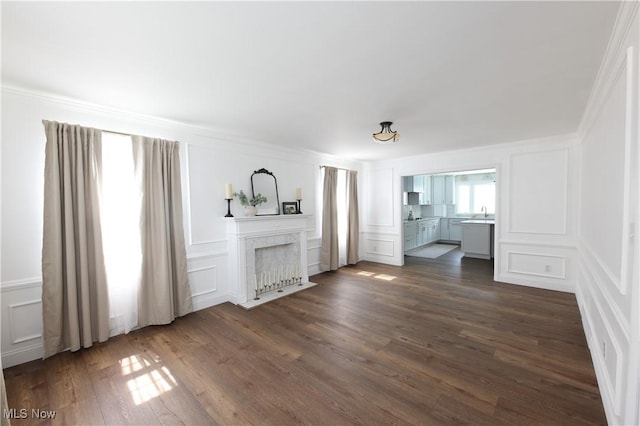 327 Country Club Blvd, Weirton, WV 26062 - unfurnished living room featuring a decorative wall, crown molding, dark wood finished floors, a high end fireplace, and a sink