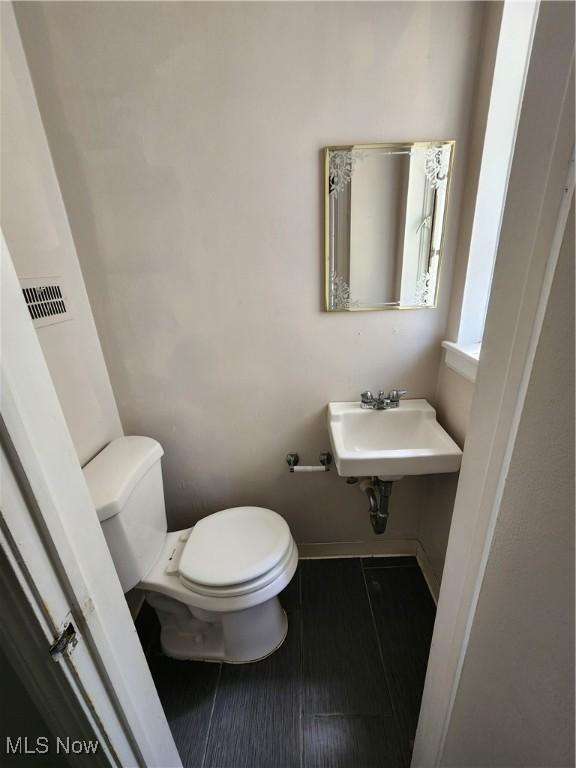1039 Argonne Rd, South Euclid, OH 44121 - half bathroom with toilet, a sink, and baseboards