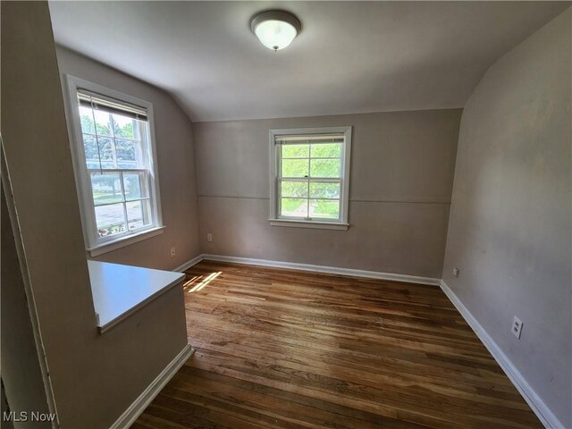 1039 Argonne Rd, South Euclid, OH 44121 - spare room featuring vaulted ceiling, dark wood-style floors, plenty of natural light, and baseboards