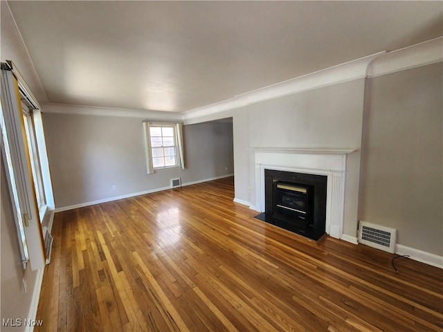 1039 Argonne Rd, South Euclid, OH 44121 - unfurnished living room featuring crown molding, hardwood / wood-style flooring, a fireplace with flush hearth, and baseboards