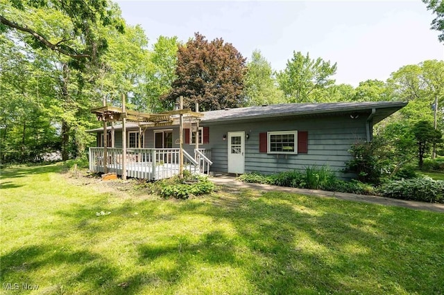18373 Bentwood Dr, Doylestown, OH 44230 - view of front of house with a wooden deck, a front lawn, and view of wooded area