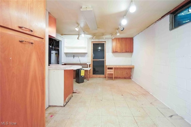18373 Bentwood Dr, Doylestown, OH 44230 - kitchen featuring open shelves, light countertops, brown cabinets, track lighting, and concrete block wall