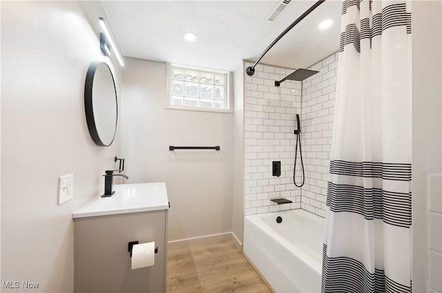 472 Saunders Ave, Coventry, OH 44319 - full bathroom with vanity, wood finished floors, recessed lighting, baseboards, and shower / tub combo