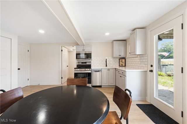 472 Saunders Ave, Coventry, OH 44319 - kitchen with appliances with stainless steel finishes, light countertops, light wood-type flooring, backsplash, and recessed lighting