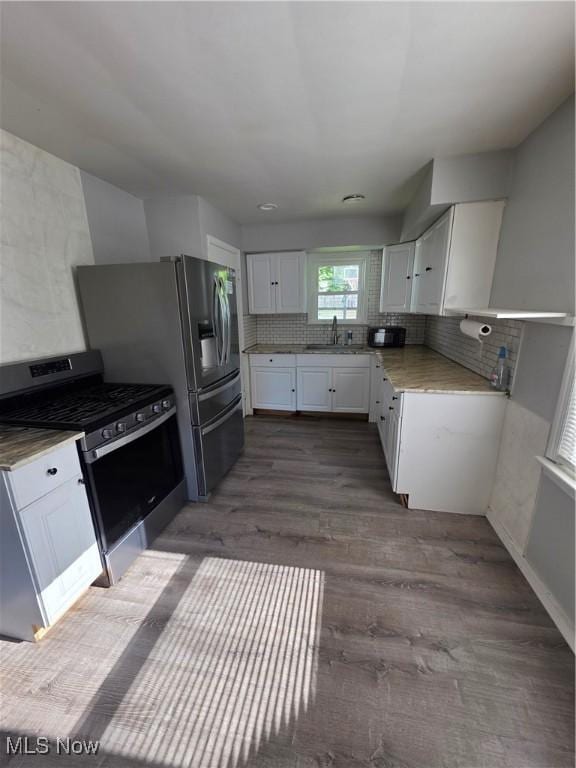 3801 Archmere Ave, Old Brooklyn, OH 44109 - kitchen featuring appliances with stainless steel finishes, decorative backsplash, white cabinets, dark wood-style flooring, and a sink