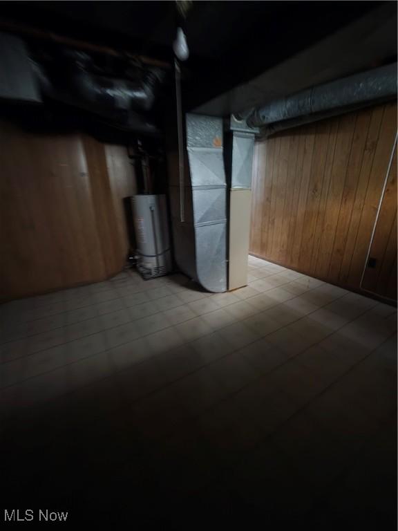 3801 Archmere Ave, Old Brooklyn, OH 44109 - unfinished basement with tile patterned floors, wood walls, heating unit, and water heater