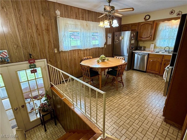 904 Donegal Dr W, Follansbee, WV 26037 - kitchen featuring stainless steel appliances, wooden walls, brick patterned flooring, plenty of natural light, and light countertops