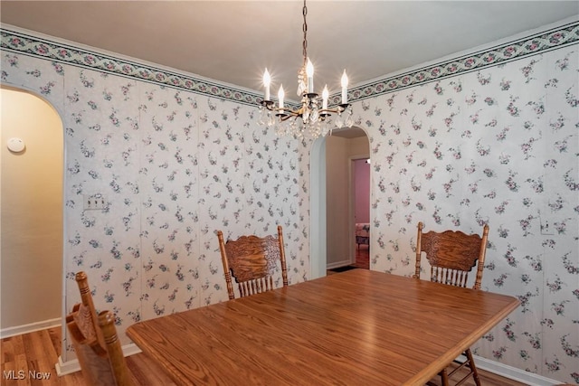 1303 28th St, Vienna, WV 26105 - dining space with arched walkways, a chandelier, baseboards, wood finished floors, and wallpapered walls