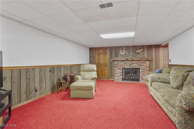 962 N Market St, Lisbon, OH 44432 - living area featuring wood walls, carpet, a fireplace, and a drop ceiling