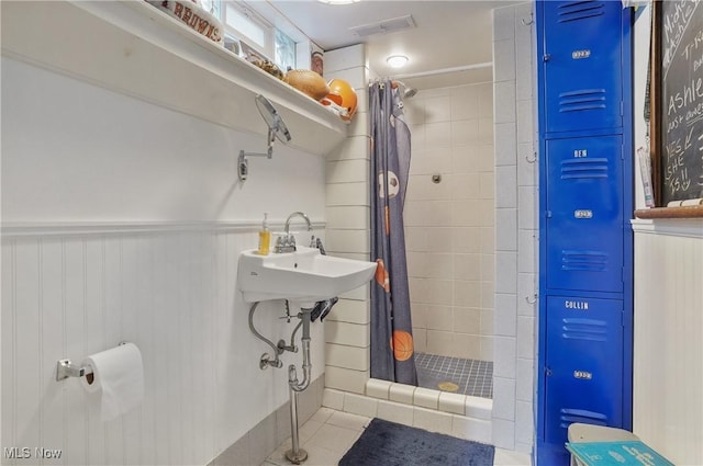 962 N Market St, Lisbon, OH 44432 - full bathroom featuring a stall shower, tile patterned flooring, a wainscoted wall, and a sink