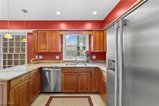 177 N Park Dr, Aurora, OH 44202 - kitchen featuring appliances with stainless steel finishes, brown cabinetry, a peninsula, light stone countertops, and pendant lighting