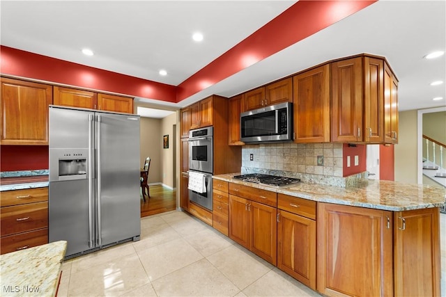 177 N Park Dr, Aurora, OH 44202 - kitchen featuring appliances with stainless steel finishes, decorative backsplash, light tile patterned floors, light stone counters, and brown cabinetry