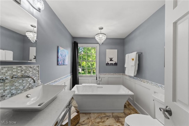 177 N Park Dr, Aurora, OH 44202 - full bath featuring a chandelier, a freestanding tub, wainscoting, vanity, and tasteful backsplash