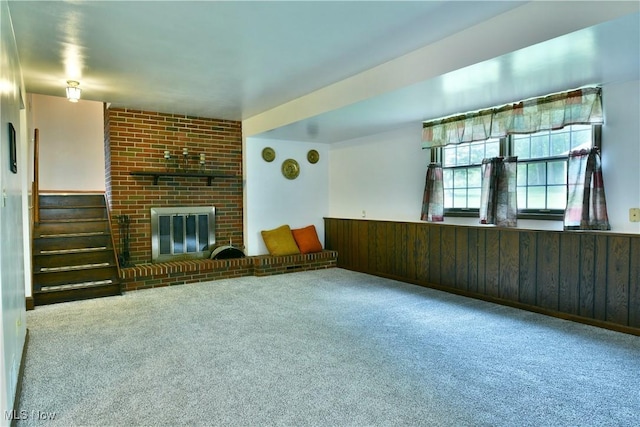 6739 Stewart Sharon Rd, Brookfield, OH 44403 - unfurnished living room with carpet floors, stairway, a fireplace, wooden walls, and wainscoting