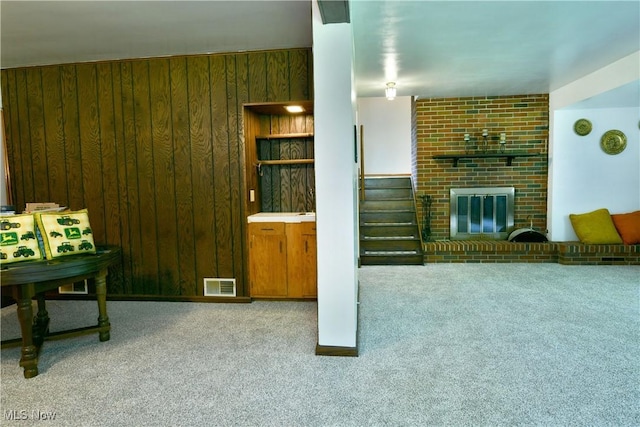 6739 Stewart Sharon Rd, Brookfield, OH 44403 - living room with carpet flooring, wood walls, a fireplace, and stairway
