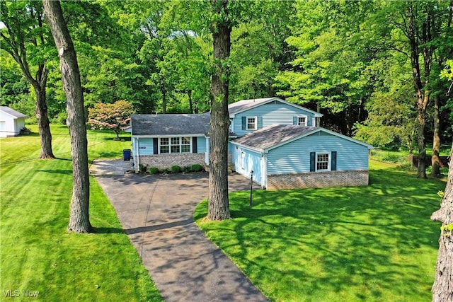 6739 Stewart Sharon Rd, Brookfield, OH 44403 - view of front of house with asphalt driveway, a front lawn, an attached garage, and brick siding