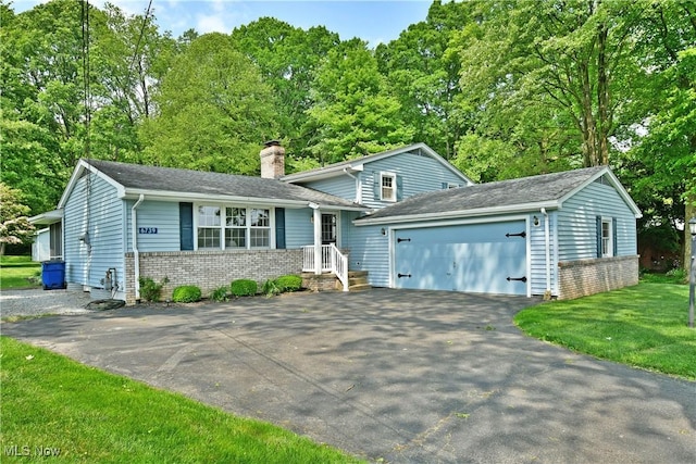 6739 Stewart Sharon Rd, Brookfield, OH 44403 - tri-level home featuring a chimney, brick siding, asphalt driveway, an attached garage, and a front lawn