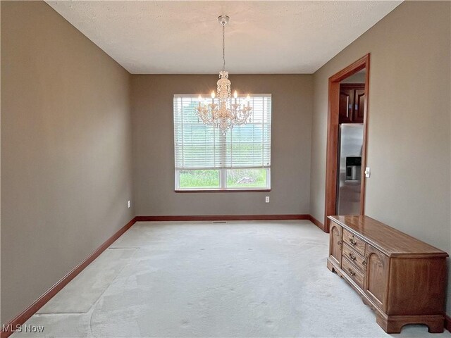 6005 Champagne, Medina, OH 44256 - spare room featuring a chandelier, light colored carpet, and baseboards