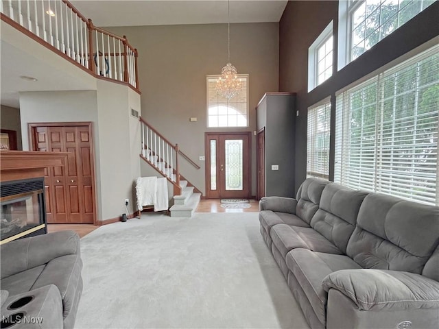 6005 Champagne, Medina, OH 44256 - living area featuring a towering ceiling, a chandelier, stairway, carpet floors, and baseboards