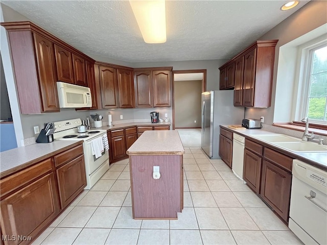 6005 Champagne, Medina, OH 44256 - kitchen with white appliances, a sink, a center island, light countertops, and a textured ceiling