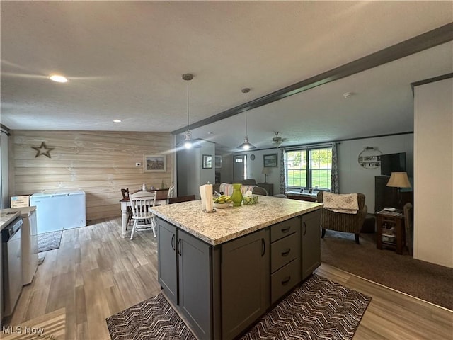 301 46th St SW, Canton, OH 44706 - kitchen featuring open floor plan, wooden walls, light wood finished floors, a kitchen island, and decorative light fixtures