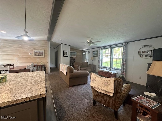301 46th St SW, Canton, OH 44706 - living area featuring a textured ceiling, vaulted ceiling, ceiling fan, wooden walls, and dark colored carpet