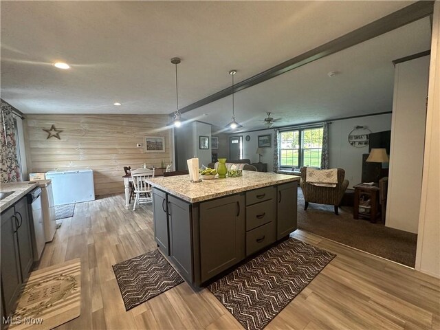 301 46th St SW, Canton, OH 44706 - kitchen with open floor plan, light wood-style flooring, a center island, wooden walls, and pendant lighting