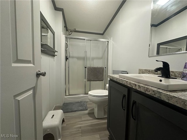 301 46th St SW, Canton, OH 44706 - bathroom featuring wood finished floors, a stall shower, vanity, toilet, and ornamental molding