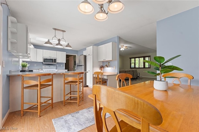 7183 Hunter Dr, Chippewa Lake, OH 44215 - dining area featuring light wood-style flooring, a chandelier, baseboards, and ceiling fan