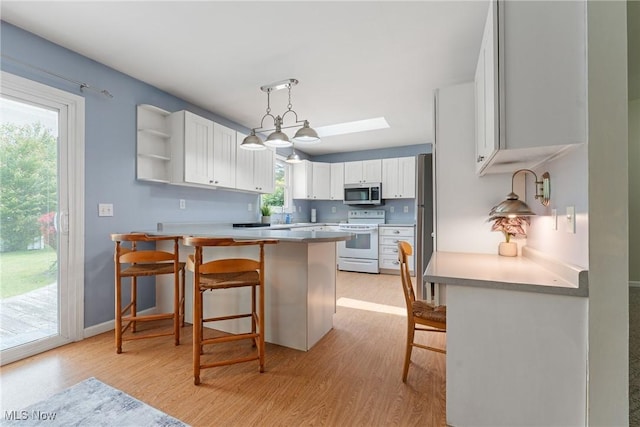 7183 Hunter Dr, Chippewa Lake, OH 44215 - kitchen with appliances with stainless steel finishes, light wood finished floors, and a kitchen breakfast bar