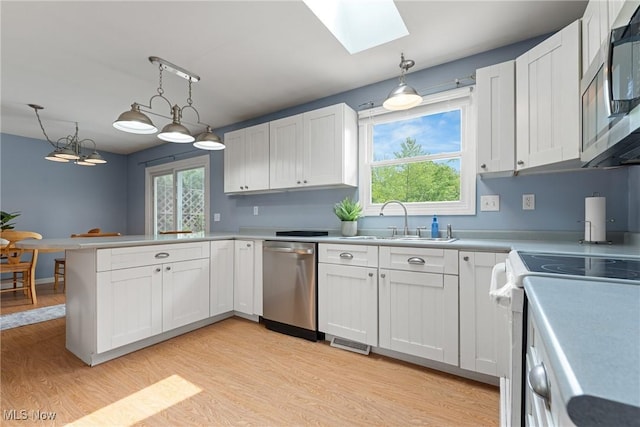 7183 Hunter Dr, Chippewa Lake, OH 44215 - kitchen featuring appliances with stainless steel finishes, a sink, a skylight, and light wood-style floors