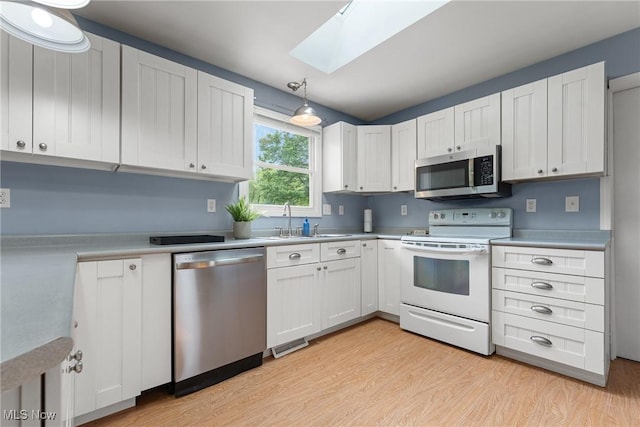 7183 Hunter Dr, Chippewa Lake, OH 44215 - kitchen featuring stainless steel appliances, a skylight, light wood-type flooring, and light countertops