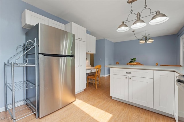 7183 Hunter Dr, Chippewa Lake, OH 44215 - kitchen featuring freestanding refrigerator, a chandelier, light wood finished floors, white cabinetry, and light countertops