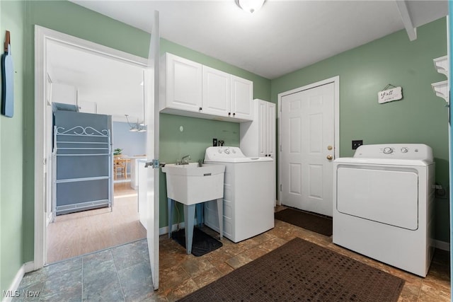 7183 Hunter Dr, Chippewa Lake, OH 44215 - laundry area featuring cabinet space, stone finish floors, washer and dryer, and baseboards