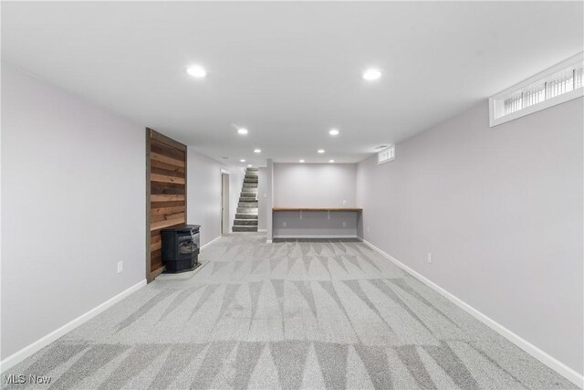 1892 Toepfer Rd, Akron, OH 44312 - finished below grade area with recessed lighting, carpet floors, baseboards, stairway, and a wood stove
