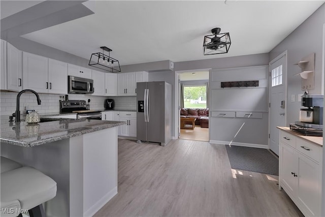1094 Jessie Ave, Kent, OH 44240 - kitchen featuring stainless steel appliances, a sink, decorative backsplash, light stone countertops, and light wood-style flooring