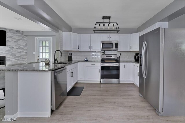 1094 Jessie Ave, Kent, OH 44240 - kitchen with appliances with stainless steel finishes, a sink, dark stone countertops, decorative backsplash, and a peninsula