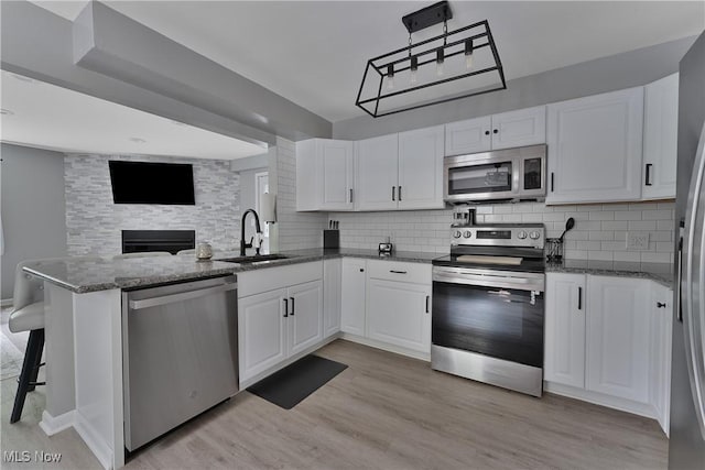 1094 Jessie Ave, Kent, OH 44240 - kitchen featuring appliances with stainless steel finishes, a sink, a peninsula, and backsplash