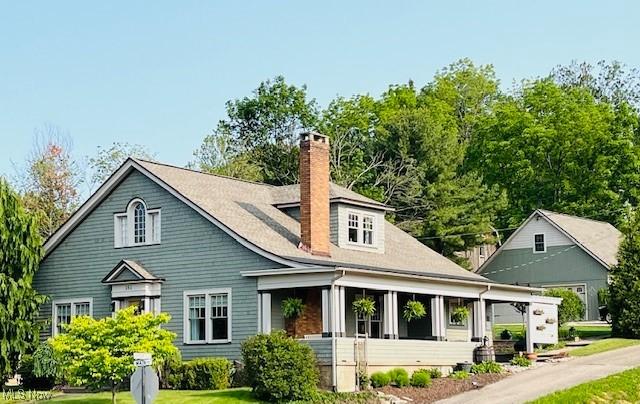 161 W Main St, New Concord, OH 43762 - back of property featuring a chimney, a sunroom, and a lawn