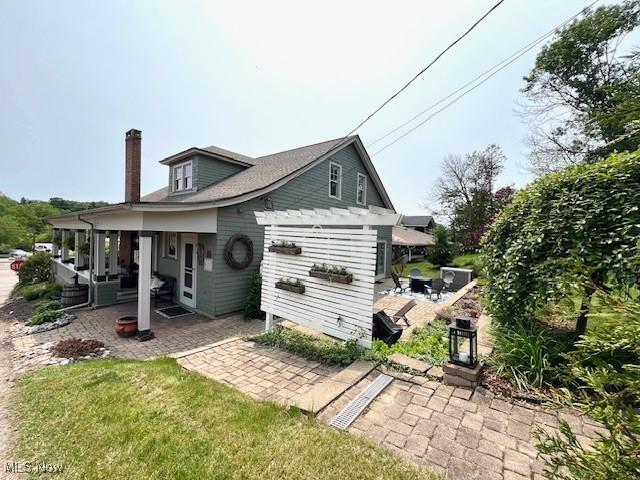161 W Main St, New Concord, OH 43762 - back of property featuring a patio area and a chimney
