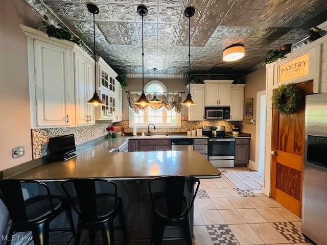 161 W Main St, New Concord, OH 43762 - kitchen featuring stainless steel appliances, an ornate ceiling, tasteful backsplash, glass insert cabinets, and a peninsula