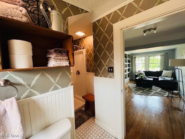 161 W Main St, New Concord, OH 43762 - bathroom featuring toilet, wainscoting, a decorative wall, and wood finished floors