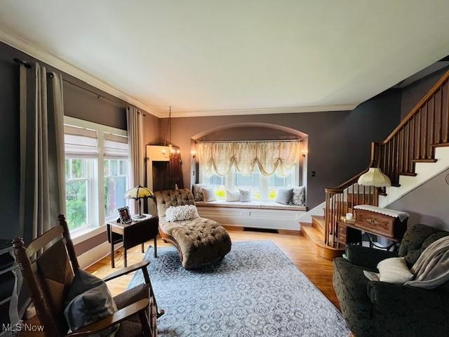 161 W Main St, New Concord, OH 43762 - living area featuring stairway, wood finished floors, and crown molding